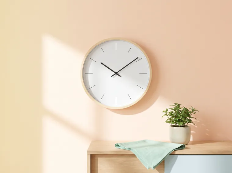 Wall clock just after ten on a peach wall